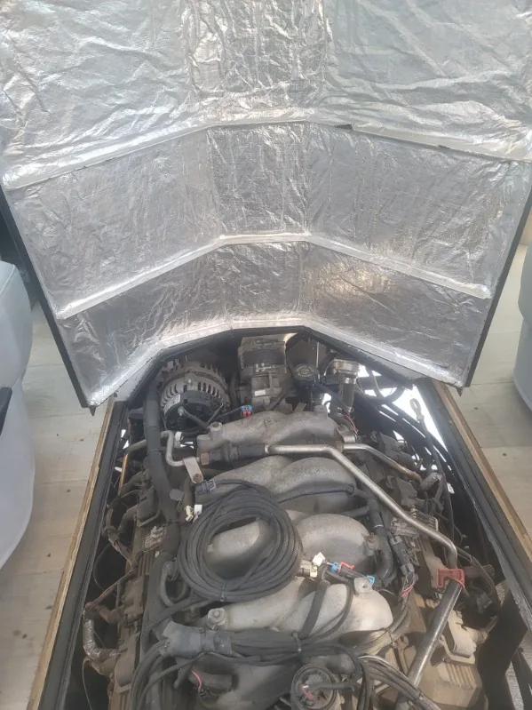 Engine bay beneath the raised hood insulation